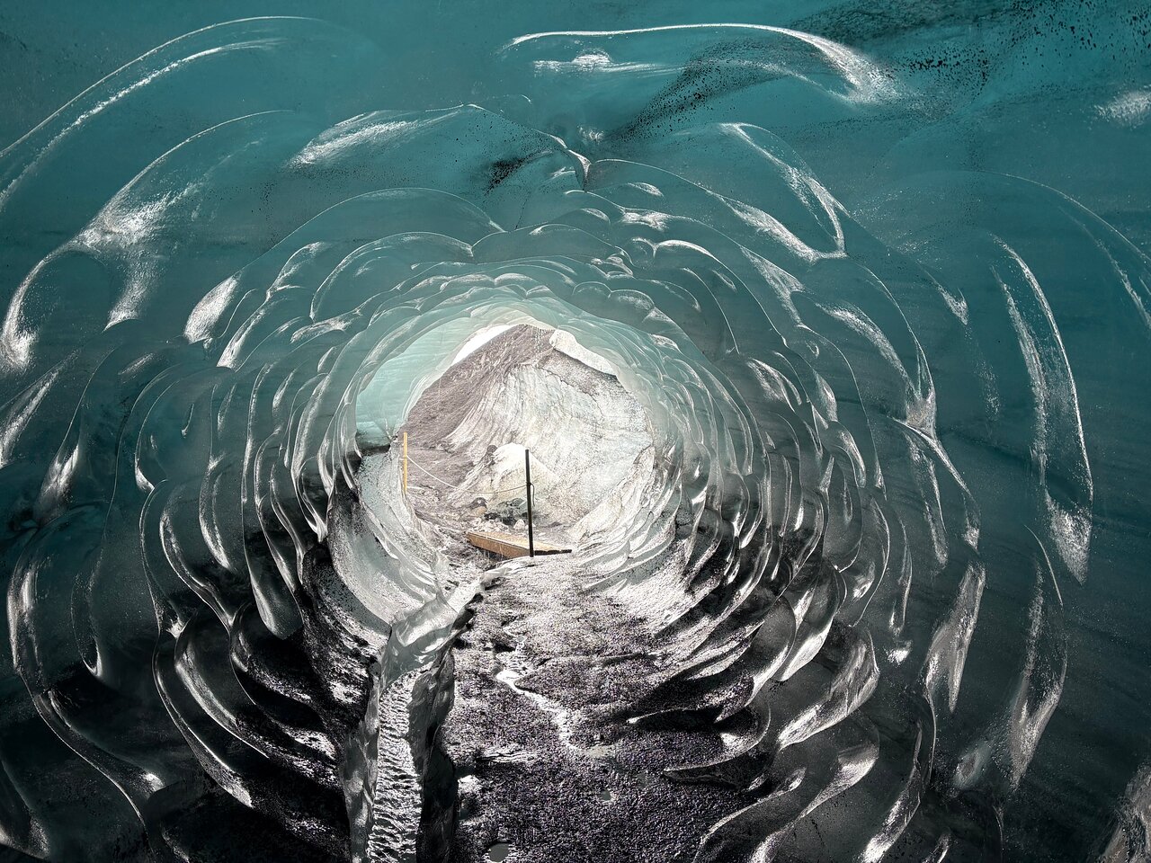 Blue and ash-streaked ice inside an Icelandic glacier ice cave